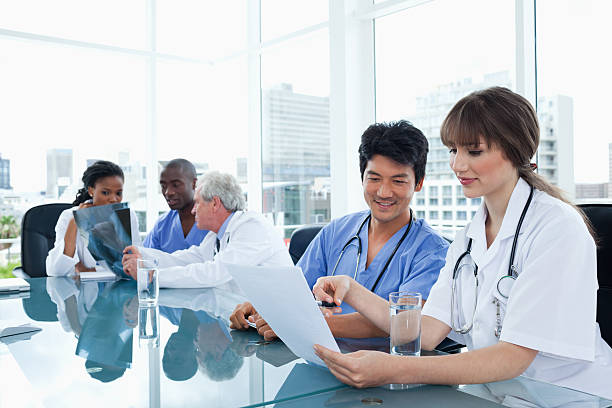 istock Smiling medical team looking at files and an x-ray 459967959