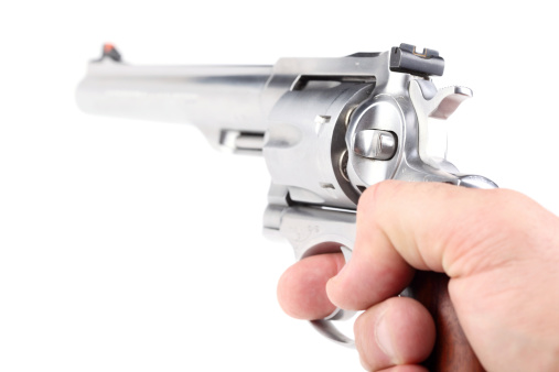 Male hand pointing a loaded 44 Magnum revolver, isolated on white background.