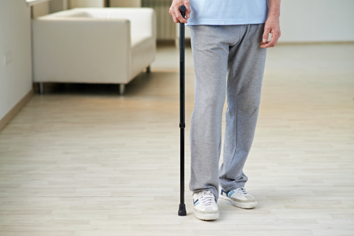 Legs of senior man walking with cane