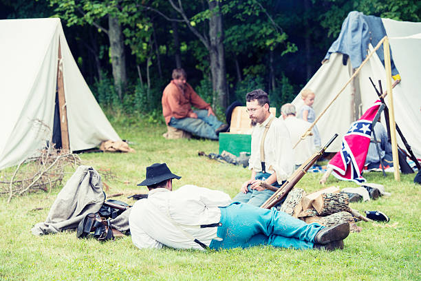 ReEnactment of Traditional Confederate Army Civil War Camp Liberty, United States - July 27, 2013: People re-enact a Confederate Civil War Camp by dressing in period clothing and setting up a historical camp. civil war enactment stock pictures, royalty-free photos & images