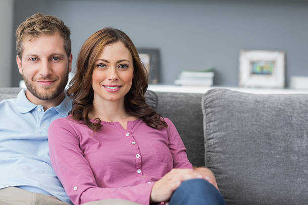istock Happy couple sitting on their couch 459975267