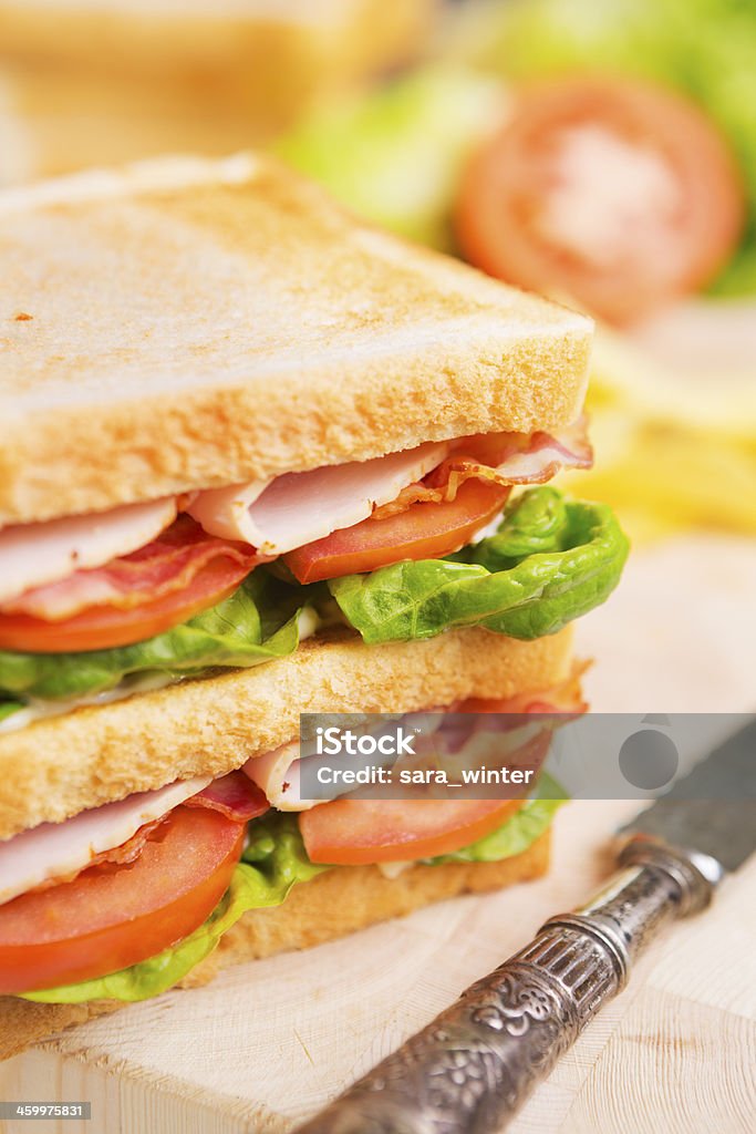 Club sandwich on a rustic table in bright light A delicious club sandwich. Bacon Stock Photo