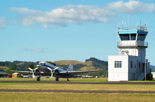 Vintage airplane and control tower in Ardmore, New Zealand.
