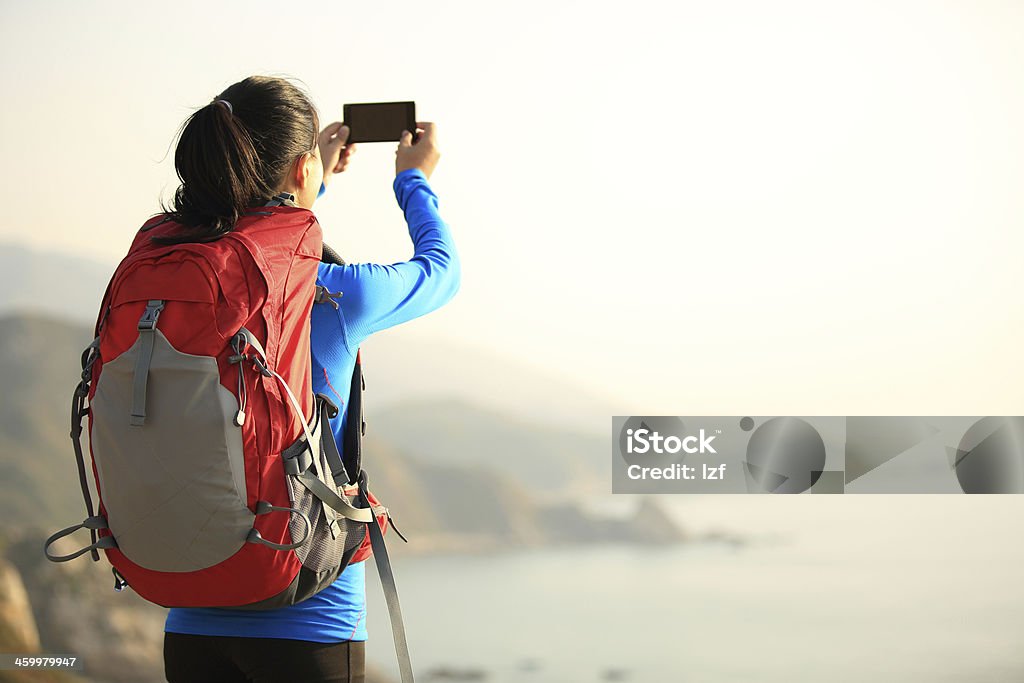 hiking woman use smart phone taking photo hiking woman use smart phone taking self photo at seaside mountain Active Lifestyle Stock Photo