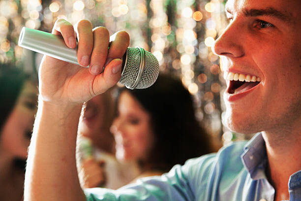 istock Close-up of young man singing at karaoke 459981119