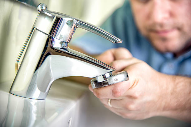 Fixing a tap Plumber fixing a tap. bathroom sink photos stock pictures, royalty-free photos & images