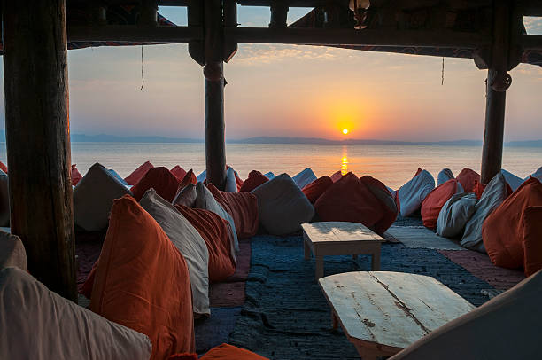 View through an empty seaside restaurant at sunrise in Dahab, Egypt. The water is the Gulf of Aqaba, and the mountains across the water are Saudi Arabia.