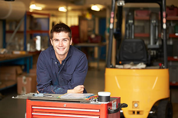 Smiling engineering apprentice in factory Portrait Of Apprentice Engineer In Factory Smiling At Camera only teenage boys stock pictures, royalty-free photos & images