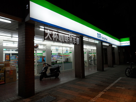Taipei, Taiwan – August 20, 2012: The front view of FamilyMart from the sidewalk in Taipei, Taiwan. There are customers inside the shop.
