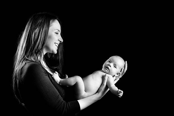 istock Young mother and baby black background 460016129