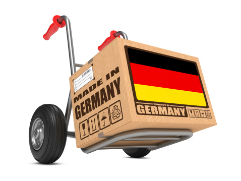 Cardboard Box with Flag of Germany and Made in Germany Slogan on Hand Truck White Background. Free Shipping Concept.