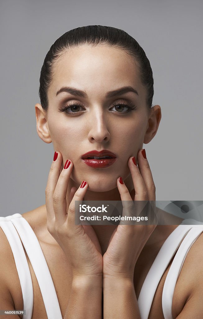 Scarlet is her color Studio portrait of a young woman wearing lipstick and nail polish 20-29 Years Stock Photo