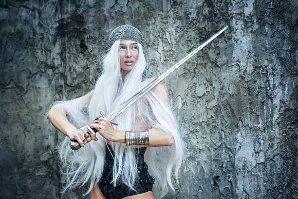 Maiden Warriors Attractive gray-haired maiden warrior in armor with sword in hand warrioresses stock pictures, royalty-free photos & images