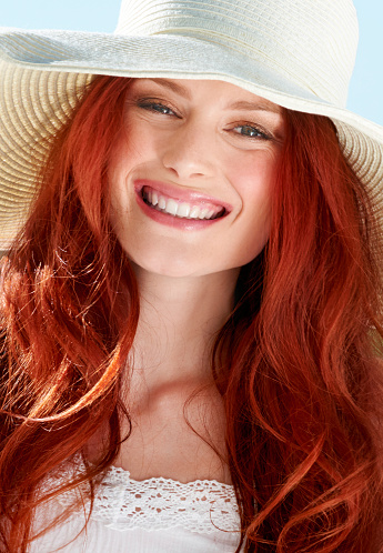 A young redheade woman wearing a sunhat