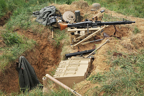 WW2 German MG42 Machine Gun In Dugout World War Two German trench/dugout with tripod mounted MG42 machine gun in it's firing position. Other pieces of German military equipment can be seen lying about in the dugout. mg42 stock pictures, royalty-free photos & images