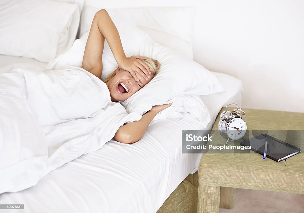 She's still sleepy A young woman yawning while waking up in the morning 20-24 Years Stock Photo