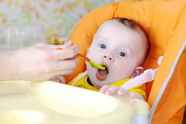 istock five-months baby is fed by puree from spoon 460080799