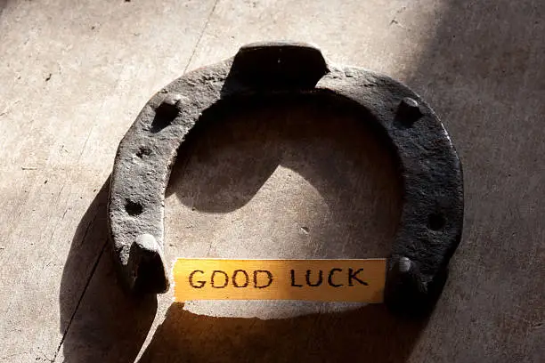good luck inscription and  horseshoe over wooden background