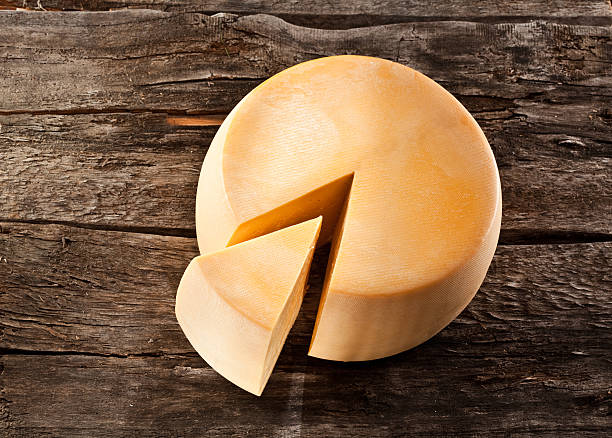 roda de queijo na mesa de madeira - cheese wheel cheese cheddar wheel imagens e fotografias de stock