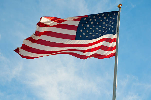 Waving American Flag in a blue sky stock photo