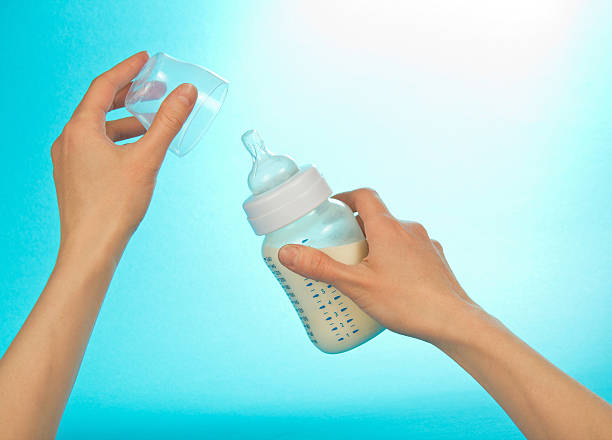 istock Hand dressing cover on small bottle for feeding 460147857