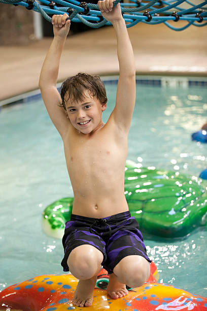 istock Young boy playing at the indoor water park 460149977
