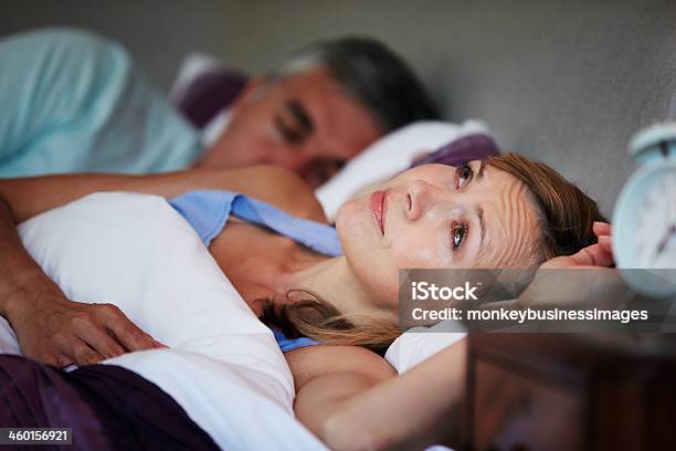 Couple In Bed With Wife Suffering From Insomnia Stock Photo - Download Image Now - Bed - Furniture, Insomnia, Women