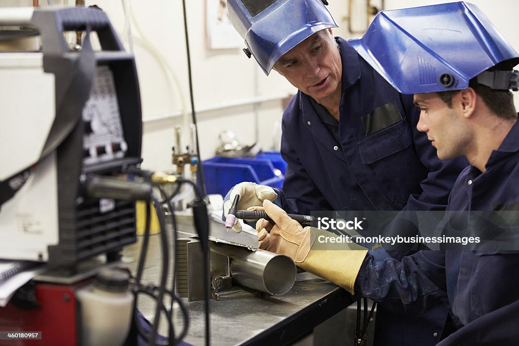 Engineer Teaching Apprentice To Use TIG Welding Machine Engineer Teaching Apprentice To Use TIG Welding Machine At Work Welder Stock Photo