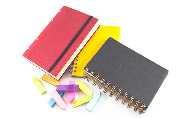 istock black,red and yellow notebooks closed isolated over white. Book 460187929