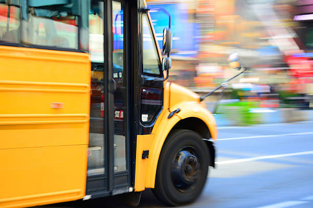 Yellow bus in the city traffic, rush hour School bus in profile / silhouette driving fast through motion blurred background.  coach bus stock pictures, royalty-free photos & images