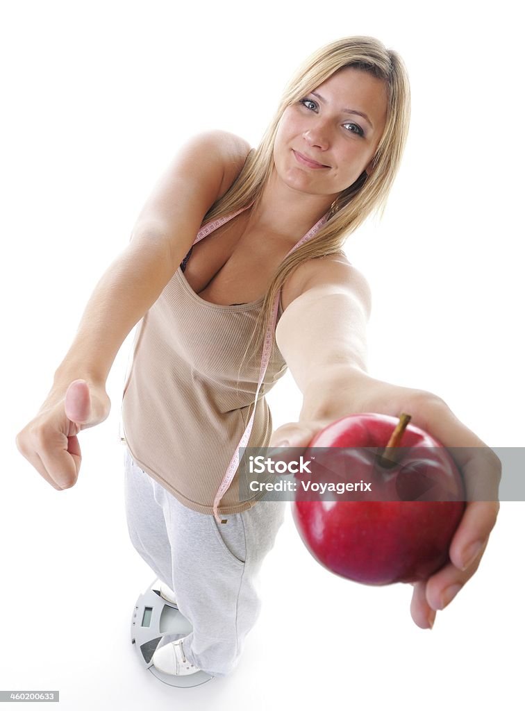 Woman plus size on scale celebrating weightloss Woman plus size large happy girl on weight scale with apple measuring tape celebrating weightloss progress after diet, thumb up gesture. Healthy lifestyles concept Achievement Stock Photo