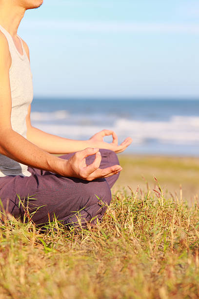 istock Cross-legged young man meditating by the sea 460202015