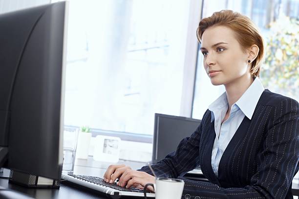 istock A woman in business attire sitting at a computer 460205143
