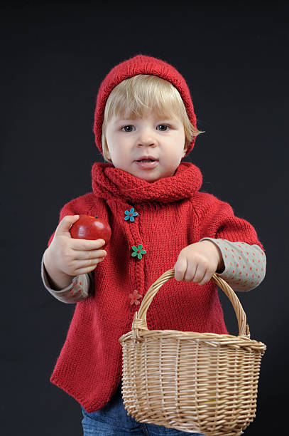 istock toddler with apple and bakset, on black 460210333