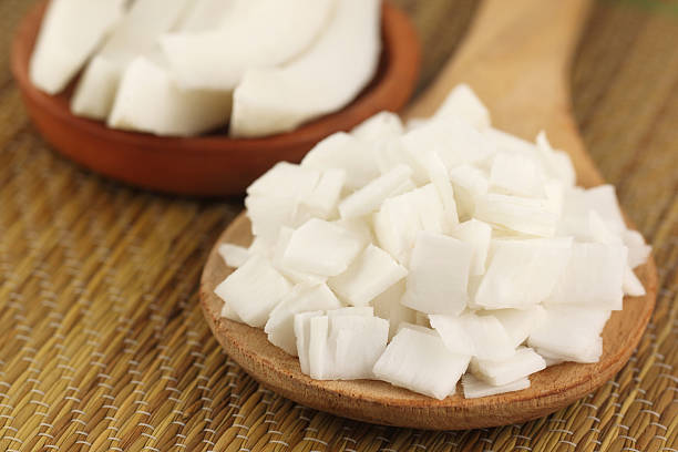 Close up of some fresh sliced coconut on wooden spoon