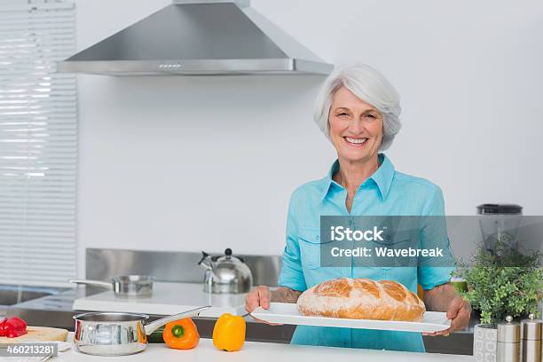 Elderly Woman Holding Bread Stock Photo - Download Image Now - 70-79 Years, Active Seniors, Adult