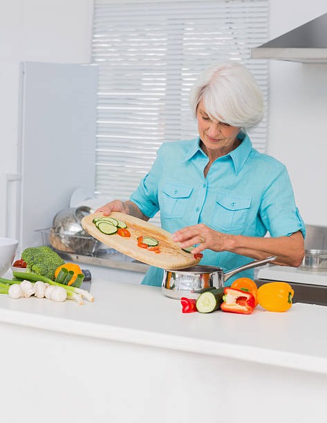 istock Woman pouring vegetable slices into a pot 460213289