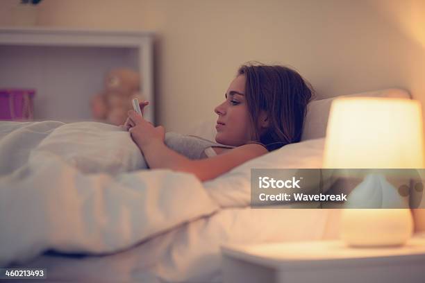 Mujer Atractiva Usando Su Smartphone Foto de stock y más banco de imágenes de Adulto - Adulto, Adulto joven, Almohada