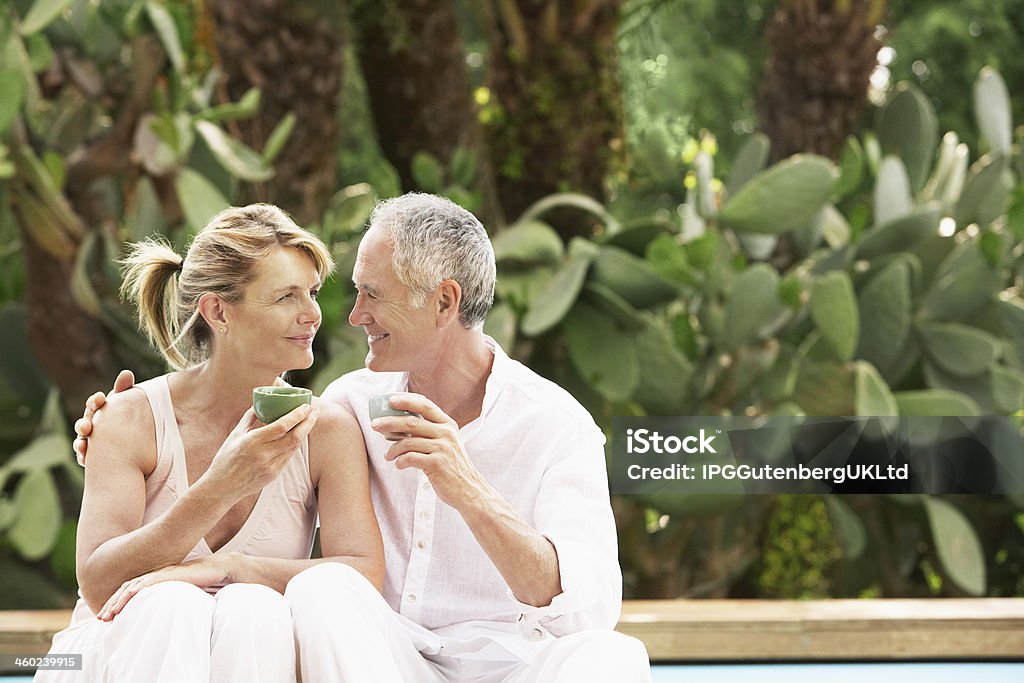 Heureux Couple assis au bord de piscine boire du thé - Photo de Adulte libre de droits