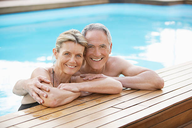 istock Older couple leaning on edge of pool and hugging 460249155