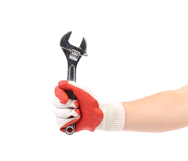 istock Hand in gloves holding wrench. 460249575