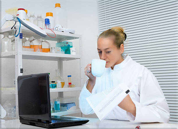 istock Scientist drinks coffe and reads paper in the lab 460253609