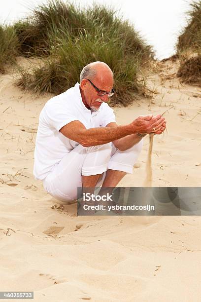 Retired Senior Man With Sand Falling From His Hands Stock Photo - Download Image Now