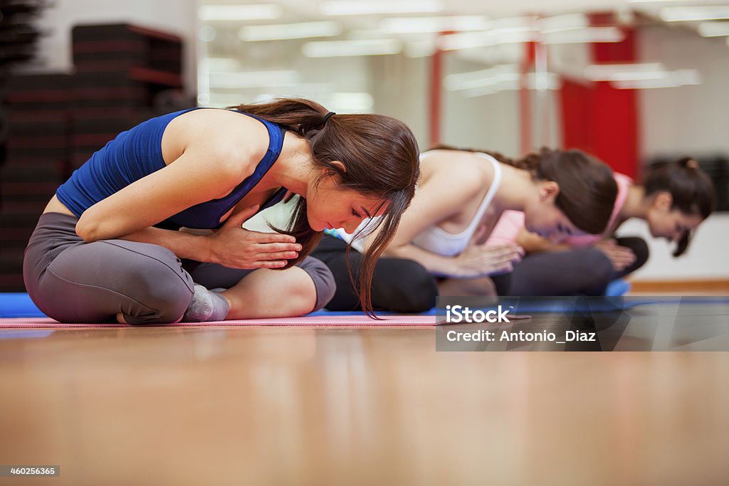 Young women meditating during yoga Group of cute Hispanic women relaxing and meditating during their yoga class in a gym 20-29 Years Stock Photo