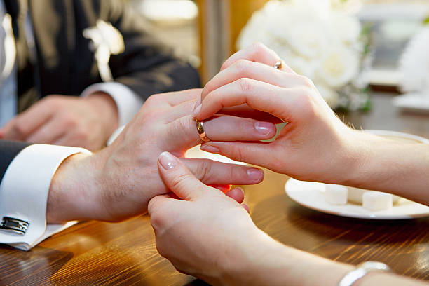 istock The bride wears a wedding ring on groom's hand. 460257863