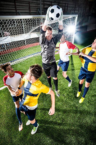 футбольный матч на стадионе: вратарь сэкономьте - soccer field flash стоковые фото и изображения