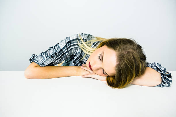 istock Tired glamorous blonde having a nap leaning on table 460258693