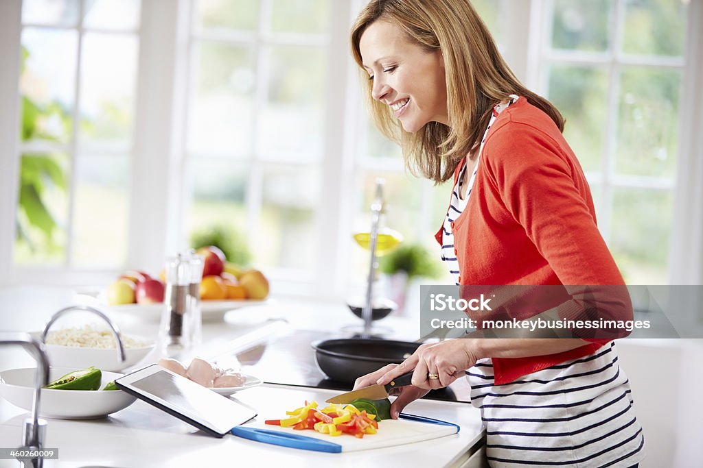Frau In der Küche nach Rezept auf Tablet PC - Lizenzfrei Frauen Stock-Foto