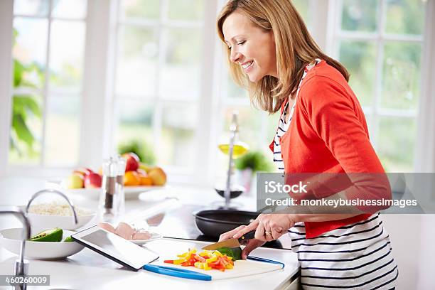 Frau In Der Küche Nach Rezept Auf Tablet Pc Stockfoto und mehr Bilder von Frauen - Frauen, Eine Frau allein, Garkochen