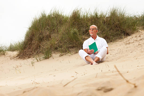 istock Retired man with beard and glasses reading a book. 460261435